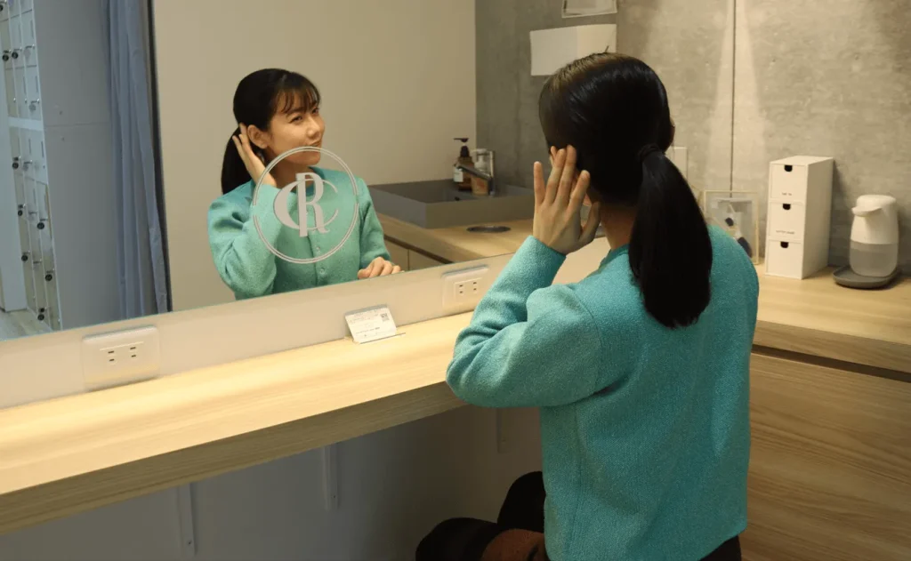 ピラティススタジオのパウダールームで身だしなみを整える女性